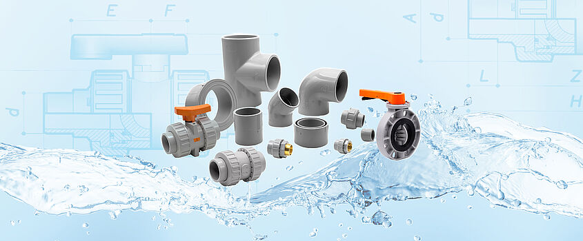 Eine Sammlung von COMER Fittings und Armaturen aus unserem PVC-C Sortiment vor einem blauen Hintergrund, angeordnet auf einer Wasserwelle